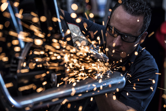 Adult mechanic welding motorbike pipe