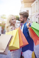 Blonde woman with boyfriends holding shopping bags
