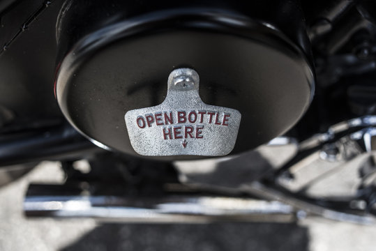 Close-up of motorbike tank with text open bottle here and arrow