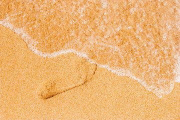 Footprint in the sand  with sea wave top view