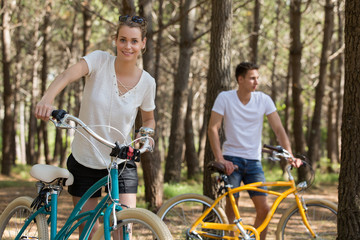 Obraz premium young couple with bicycle in forest
