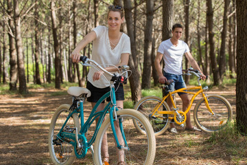 Fototapeta na wymiar young couple with bicycle in forest