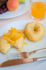 Breakfast including donuts with candied orange jam