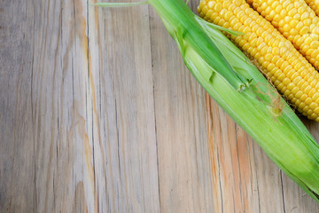 Fresh corn on cobs on rustic wooden table