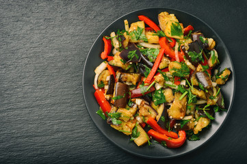 Appetizer - asian salad with eggplants, paprika and garlic on black background.