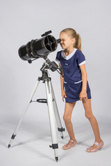 Young funny astronomer looks through the eyepiece of the telescope