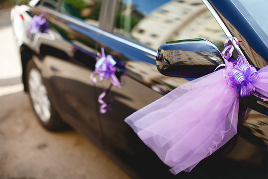 Black wedding car decorated with the purple fatin