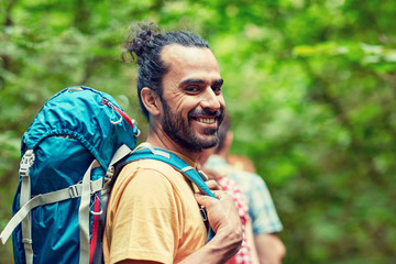 group of smiling friends with backpacks hiking