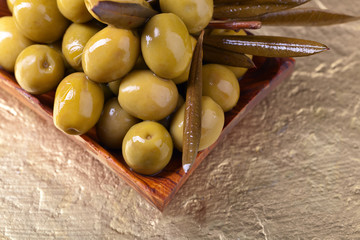 green olives in wooden dish