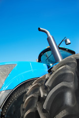 Obraz premium Tire on blue tractor close up