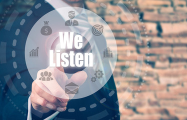 A businessman selecting a We Listen Concept button on a circular panel