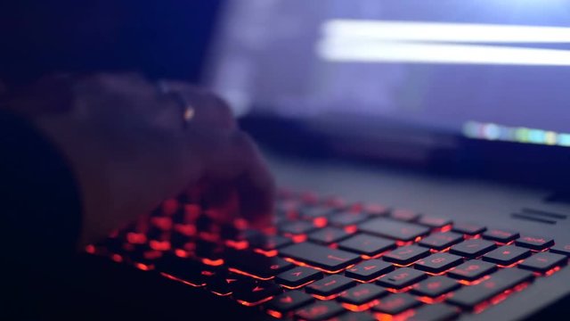 Hacker using laptop. Lots of digits on the computer screen.