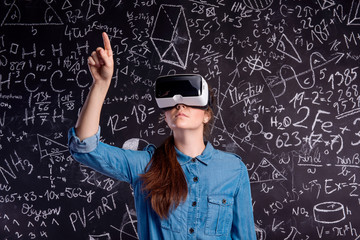 Beautiful woman wearing virtual reality goggles against big blac