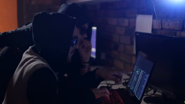 Hacker using laptop. Lots of digits on the computer screen.