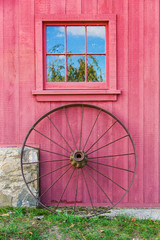 Fototapeta na wymiar Red Barn Window and Wagon Wheel