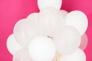 close up of white helium balloons over pink