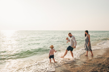 Family with children walking on the sea coast. Family portrait on vacation