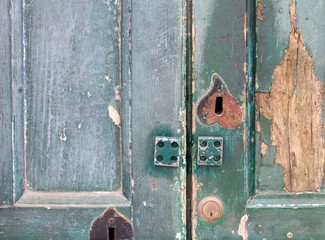 fragment of old wooden door with keyhole and door lock close-up