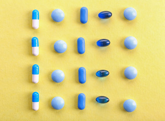 Heap of pills on yellow background