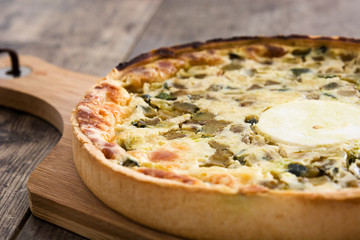 French quiche Lorraine with vegetables on a rustic wooden table

