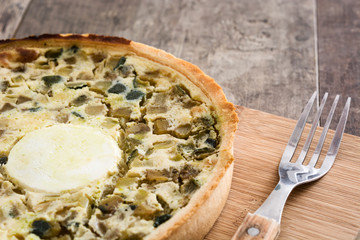 French quiche Lorraine with vegetables on a rustic wooden table

