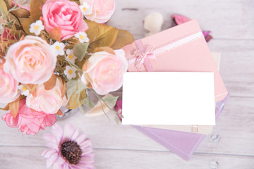 Picture of gift box with pink rose flower and gift card on wooden