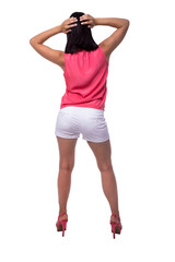 Fototapeta premium Beautiful, attractive young woman in blouse and short shorts with an elegant figure, buttocks, ass, standing backwards