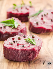 Pieces of beef tenderloin on the wooden cutting board.