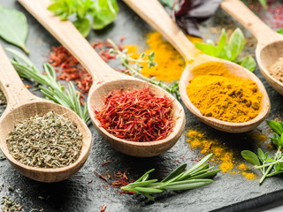 Assortment of colorful spices in the wooden spoons.