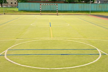 Empty outdoor handball playground, plastic light green surface