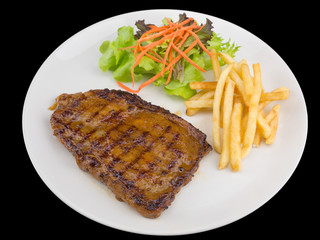 Spicy Grilled chicken steak served with french fries and salads to vegetables isolated on the black background with clipping path