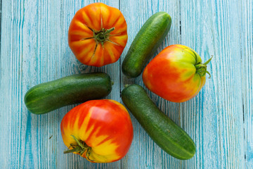 ripe raw tomatoes and cucumbers on wooden background