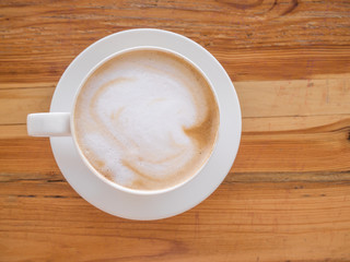 Selective focus blur a cup of Coffee latte on the wooden table