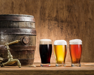 Glasses of  beer and ale barrel on the wooden table. Craft brewe