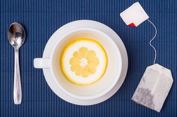 simple composition with tea cup empty but with slice of lemon and a tea bag