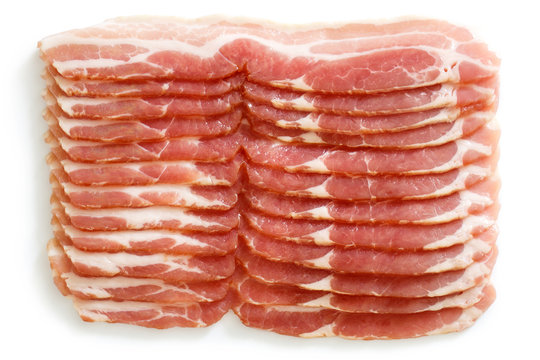 Many strips of streaky uncooked bacon isolated on white from above.