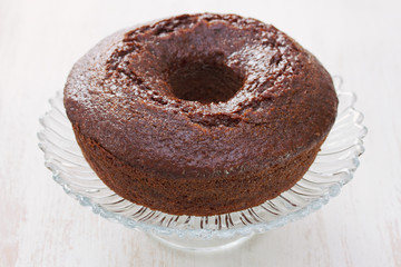 chocolated cake on dish on white wooden background