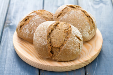 bread on wooden dish on blue background