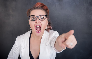 Angry screaming teacher pointing out on blackboard background