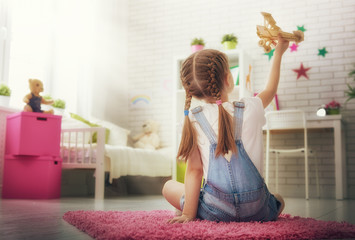 girl playing with toy airplane