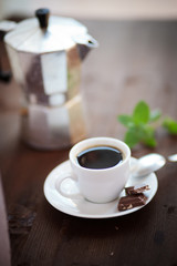 Filiżanka czarnej kawy z kostkami czekolady i listkiem mięty © gryzli