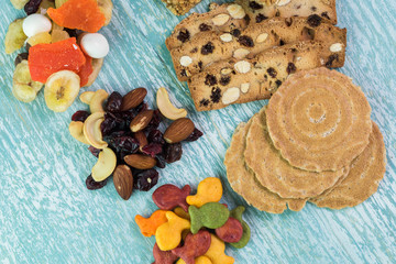 Variety of snacks. Sweet tropical nut trail mix, granola bars, goldfish crackers, almond biscuits.