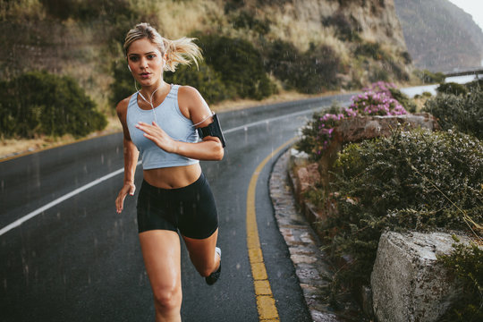 Female athlete running outdoors on highway
