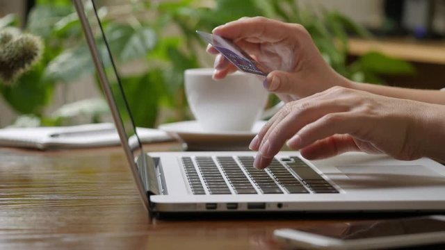 Shopping online concept. Woman hands holding credit card and using laptop.  High quality shot, UHD, 4K