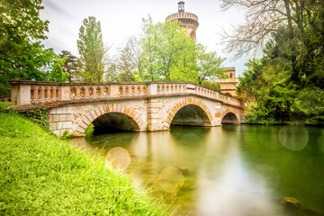 View on the bridge and tower of Franzensburg castle in Laxenburg town in Austria. Long exposure image effect with glossy water and reflection.