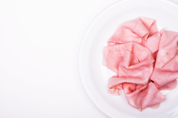 Ham slices on a white plate. From above