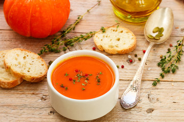 Pumpkin cream soup with thyme and pink pepper. Delicious healthy lunch