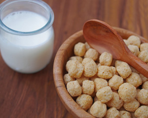 Traditional children's breakfast - corn balls in wooden bowl with fresh milk