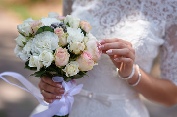 Obraz na płótnie Canvas Bride is holding beautiful bright wedding bouquet