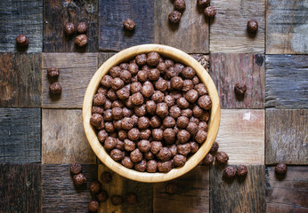 Sweet chocolate balls for breakfast in a bowl, wood background,